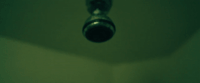 a close up of a bathroom faucet on a green wall