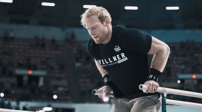 a man on a balance beam in a gym