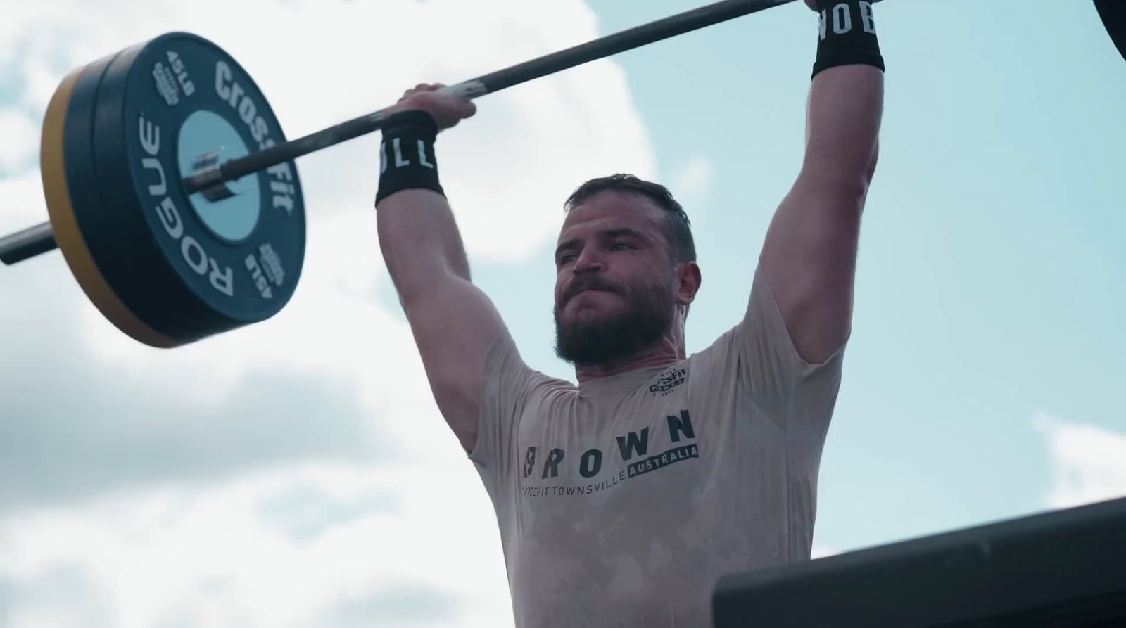 a man holding a barbell above his head