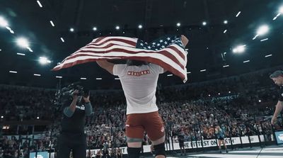 a man holding an american flag in front of a crowd