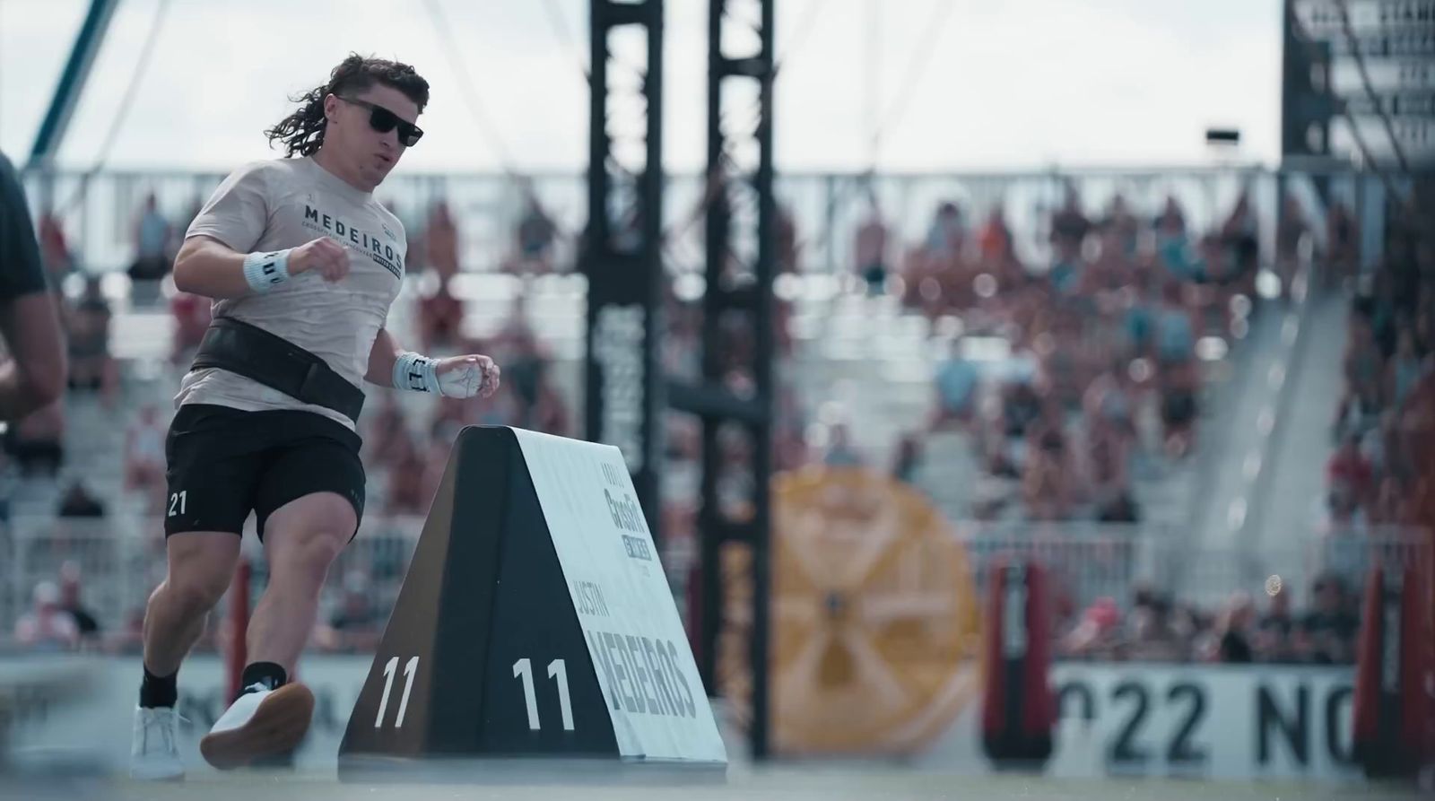 a man in a white shirt and black shorts running on a track