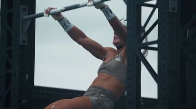 a woman is doing a pull up on a bar