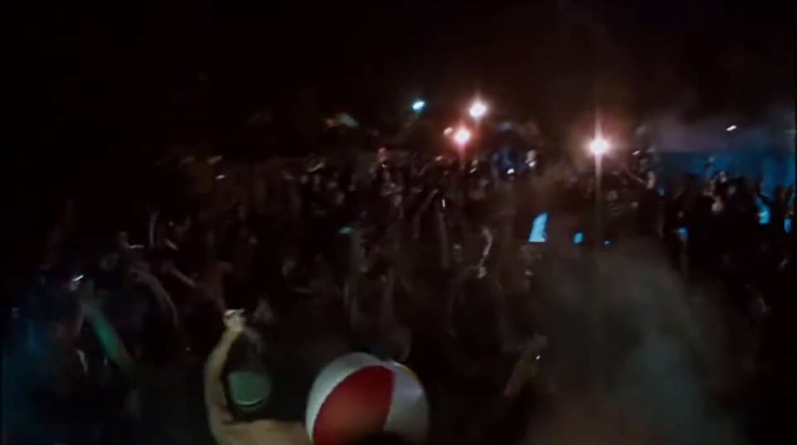 a crowd of people standing around a beach ball