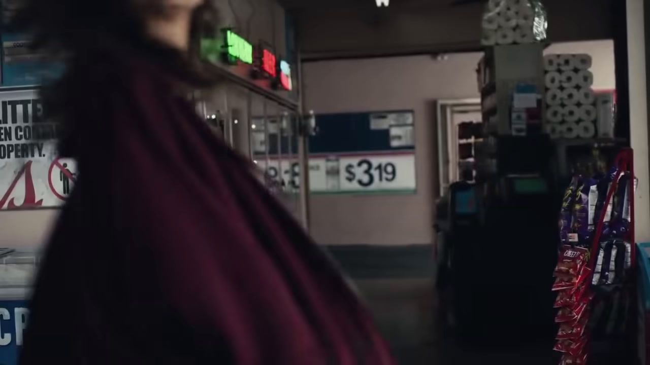 a woman in a red cape standing in a store