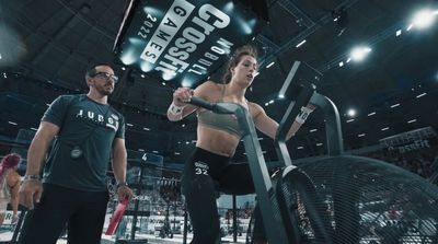 a man and a woman standing in front of a crossfit machine