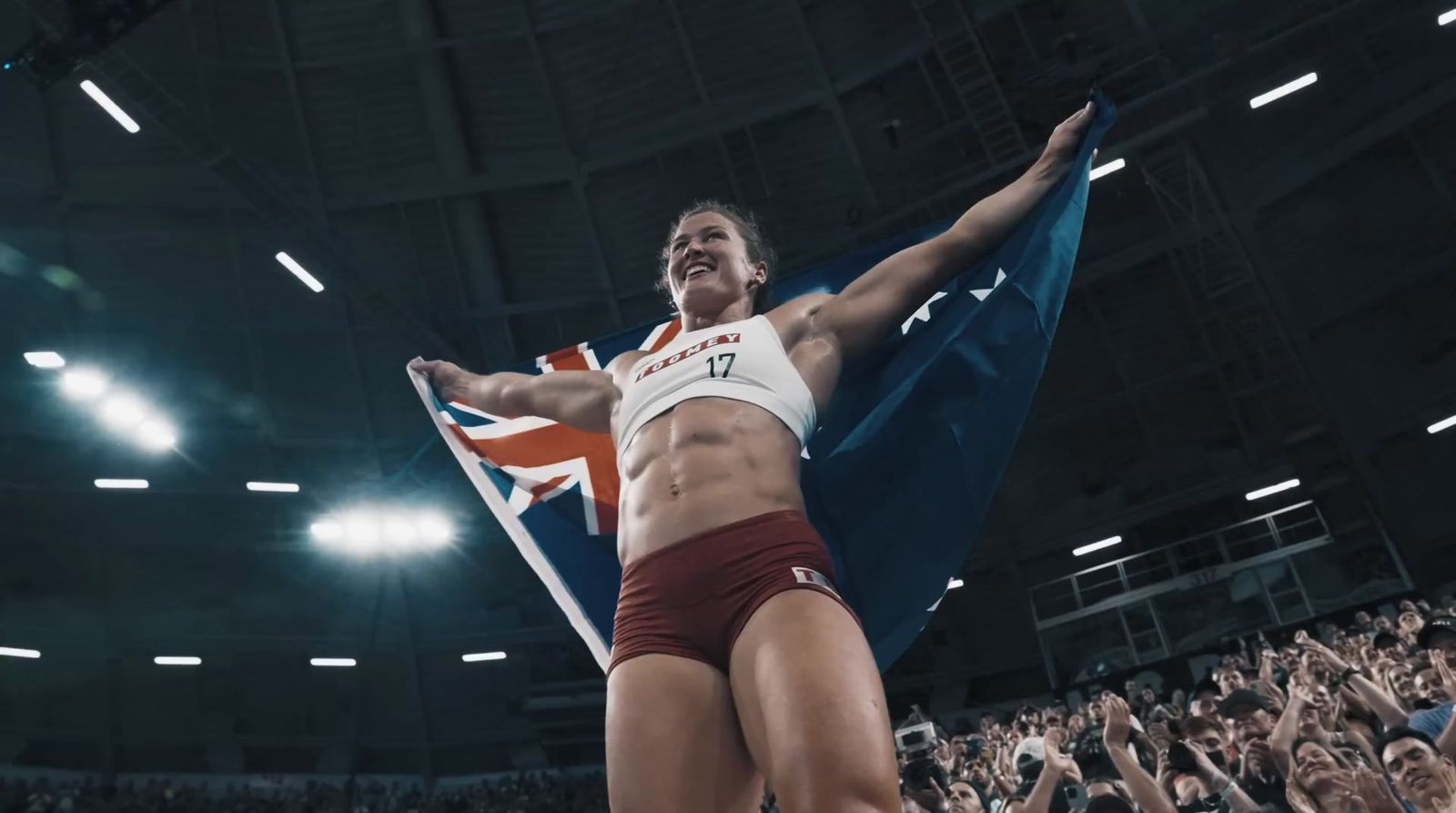 a woman holding a flag in front of a crowd