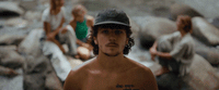 a man with no shirt standing in front of a group of people