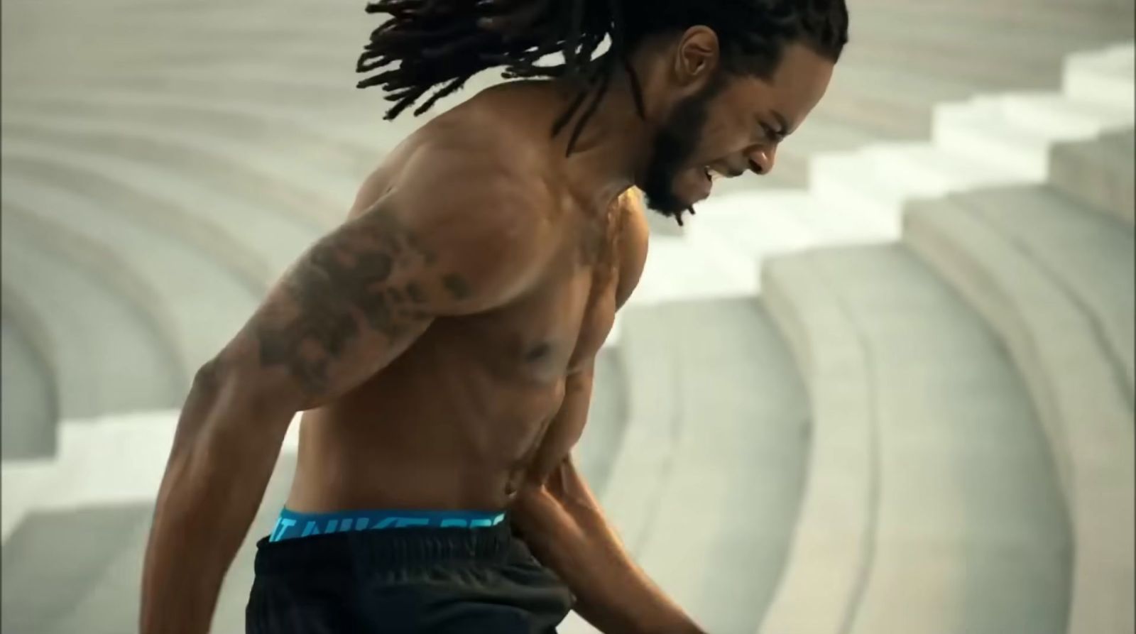 a man with dreadlocks standing in a stadium