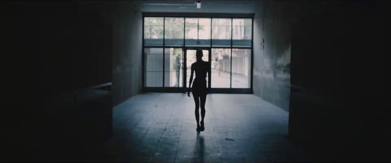 a person standing in front of a window in a dark room