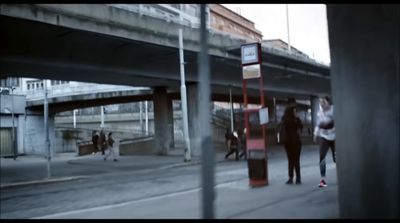 a group of people walking down a street next to a bridge