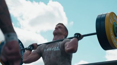 a man lifting a barbell with a sky background