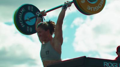 a woman holding a barbell above her head