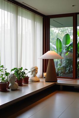 a lamp sitting on top of a table next to a window