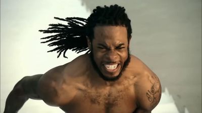 a shirtless man with dreadlocks on his head