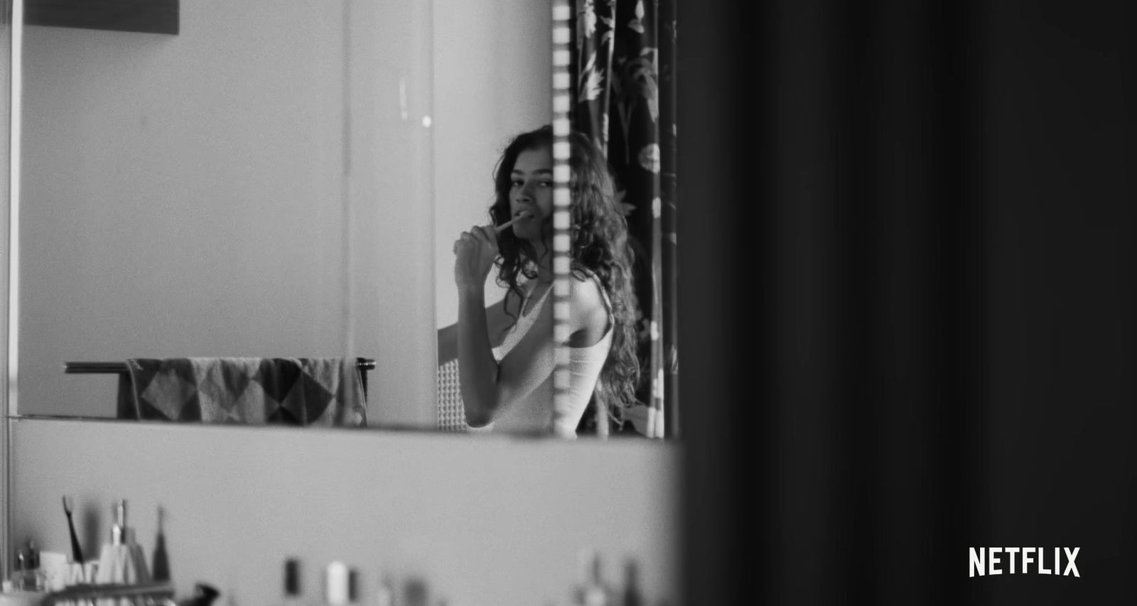 a woman standing in front of a bathroom mirror