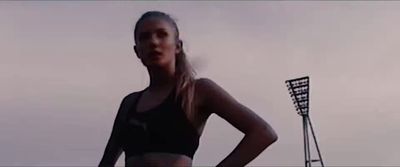 a woman standing in front of a soccer goal