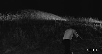 a person walking in a field at night