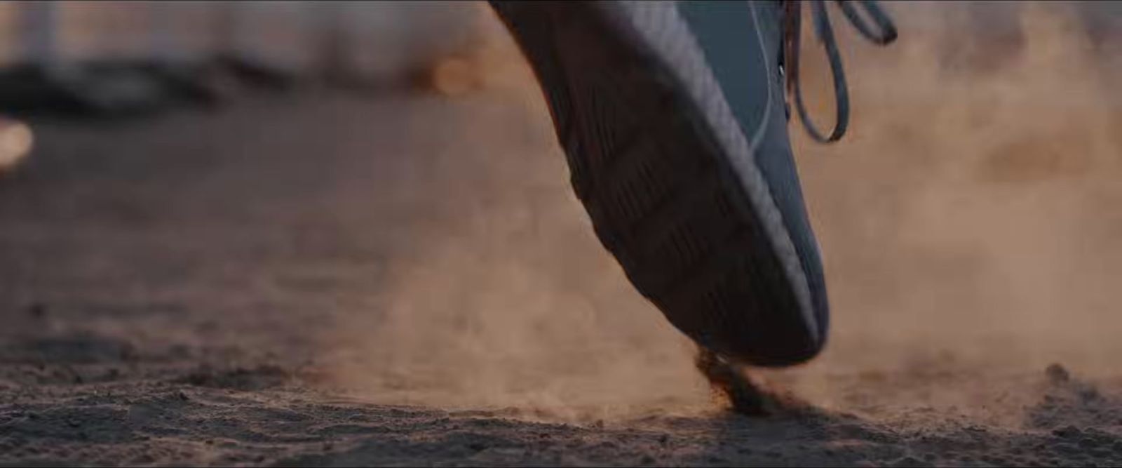 a close up of a person's foot with dirt on the ground