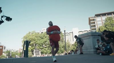 a man in a red suit running down a street