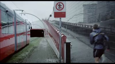 a man walking down a sidewalk next to a train