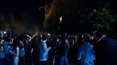 a crowd of people standing around each other at night