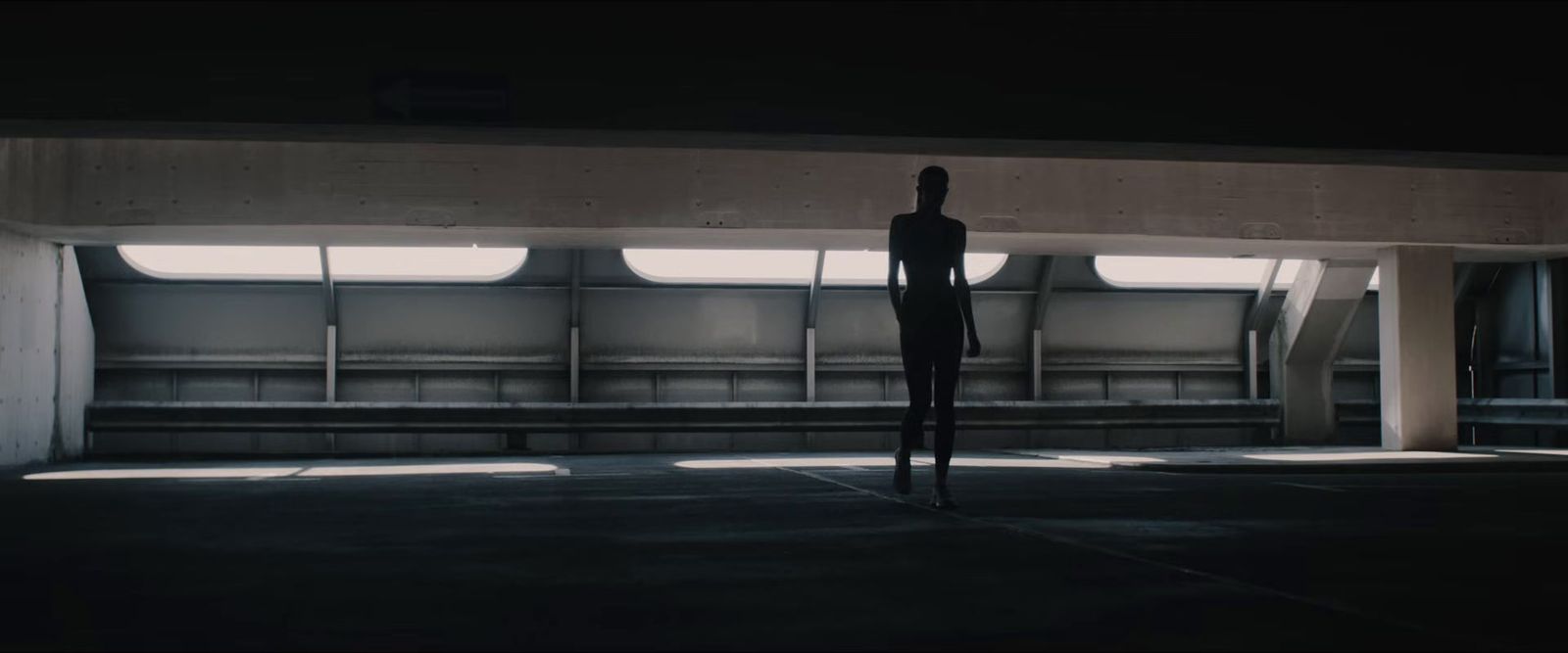 a person standing in an empty parking garage