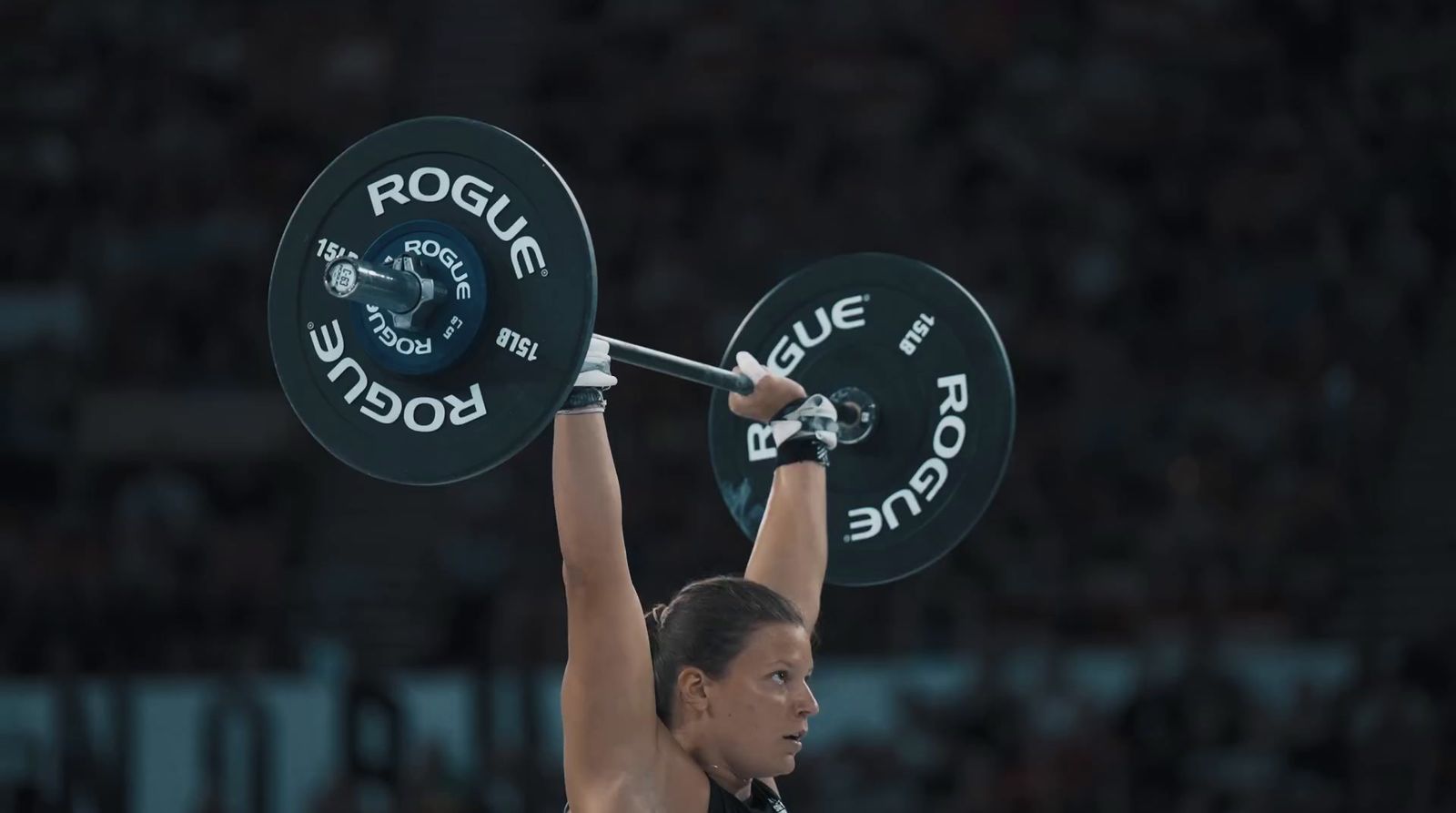 a woman lifting a barbell in a competition