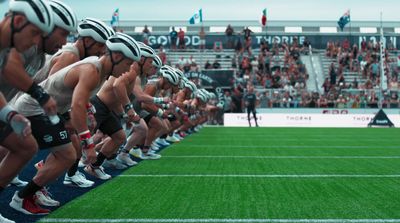 a row of men in shorts and helmets on a field