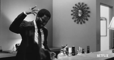 a man in a suit and tie standing in front of a bar