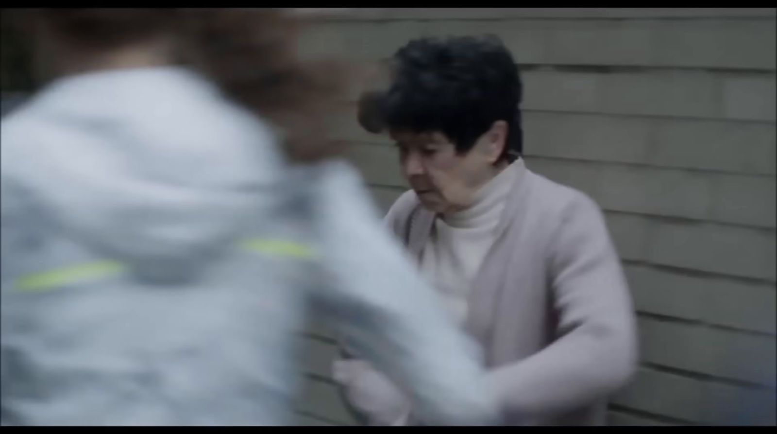 a blurry image of a woman standing in front of a building