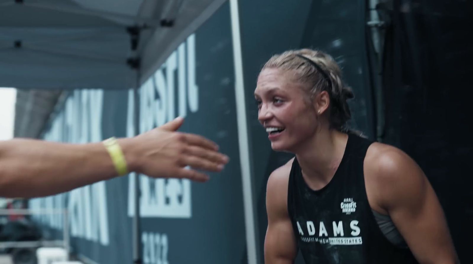 a woman in a black tank top talking to a man