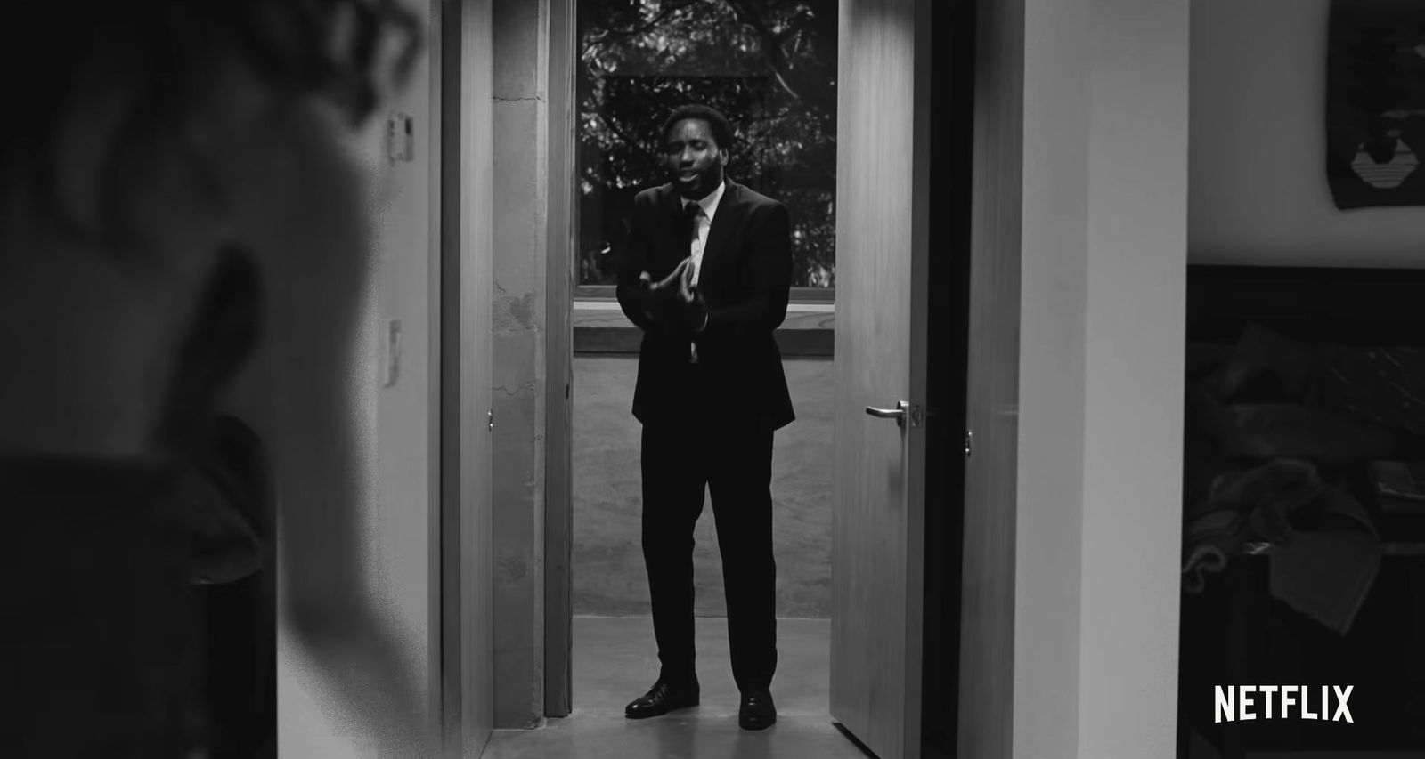 a man in a suit standing in a doorway