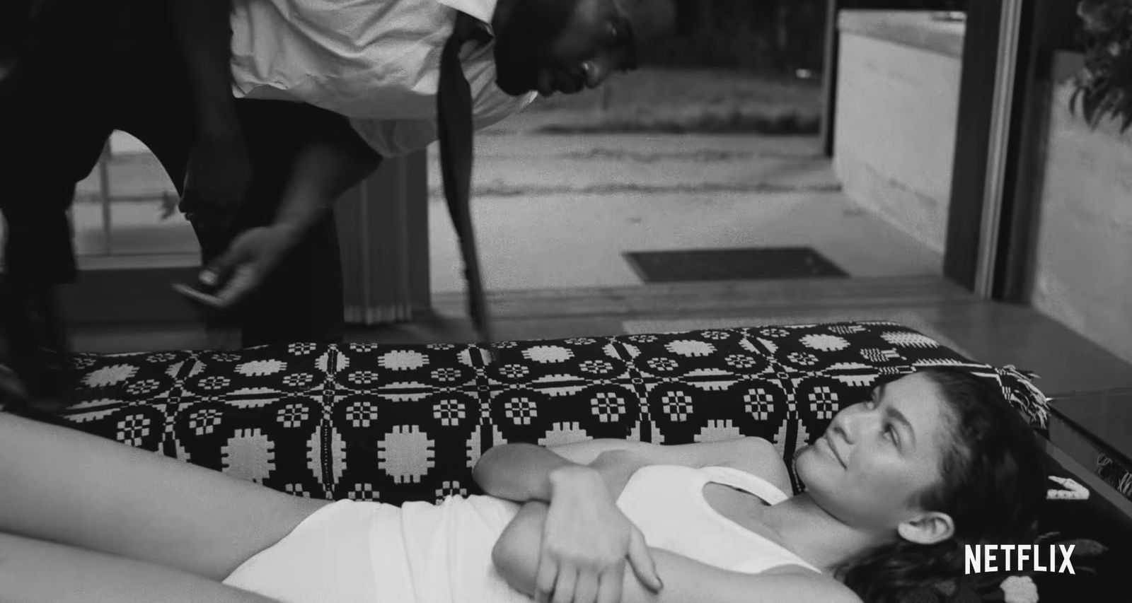 a woman laying on top of a bed next to a man