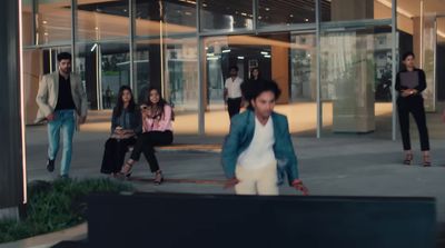 a group of people walking down a sidewalk next to a building