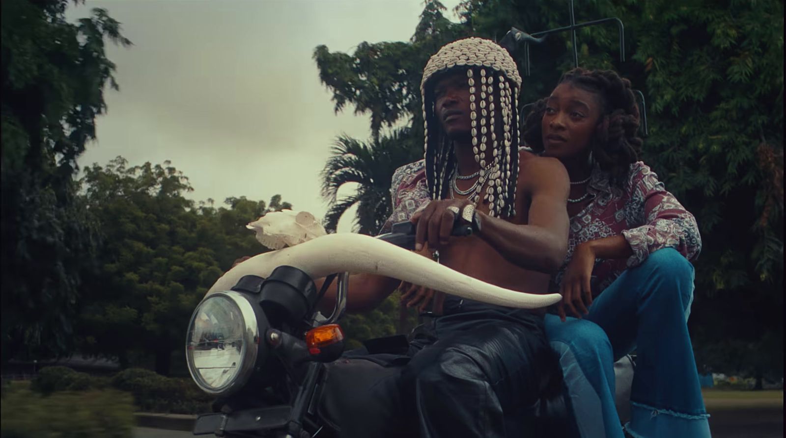 a man and a woman sitting on a motorcycle