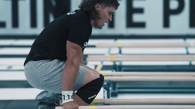 a man squatting on a bench in a gym