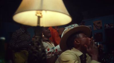 a group of people sitting around a table next to a lamp