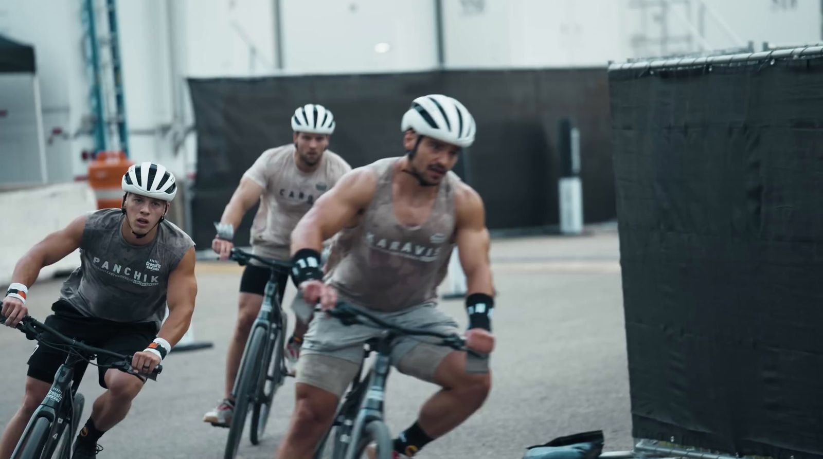 a group of men riding bikes down a street