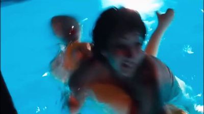 a blurry photo of a boy swimming in a pool