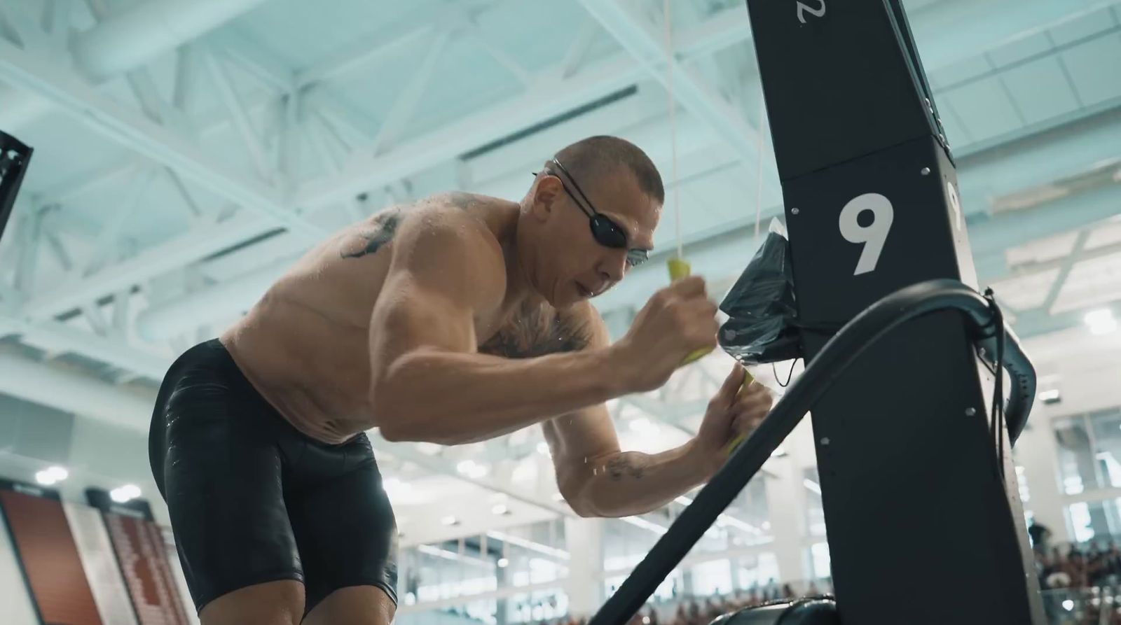 a man with no shirt on working on a machine