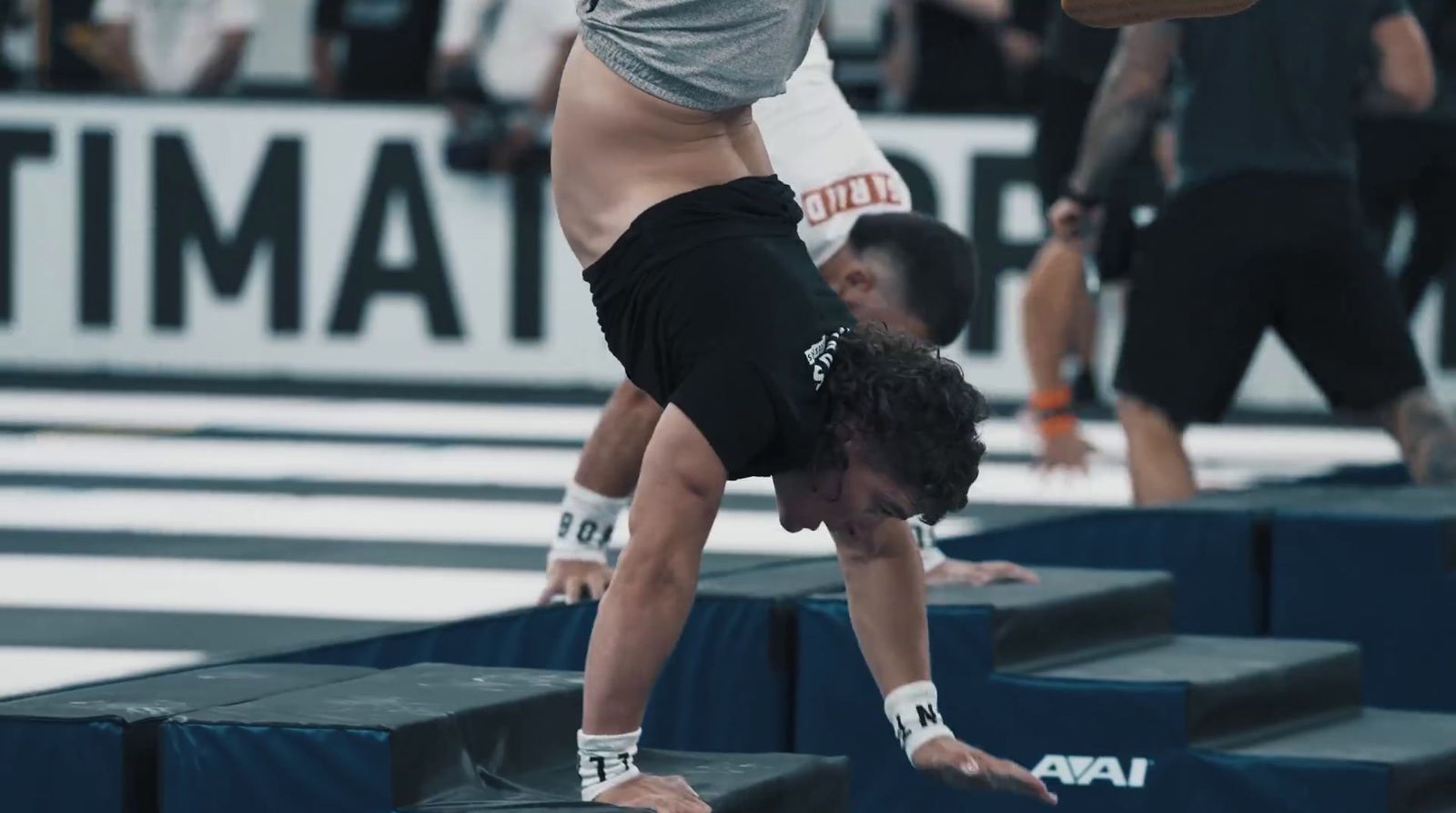 a man doing a handstand on a balance beam