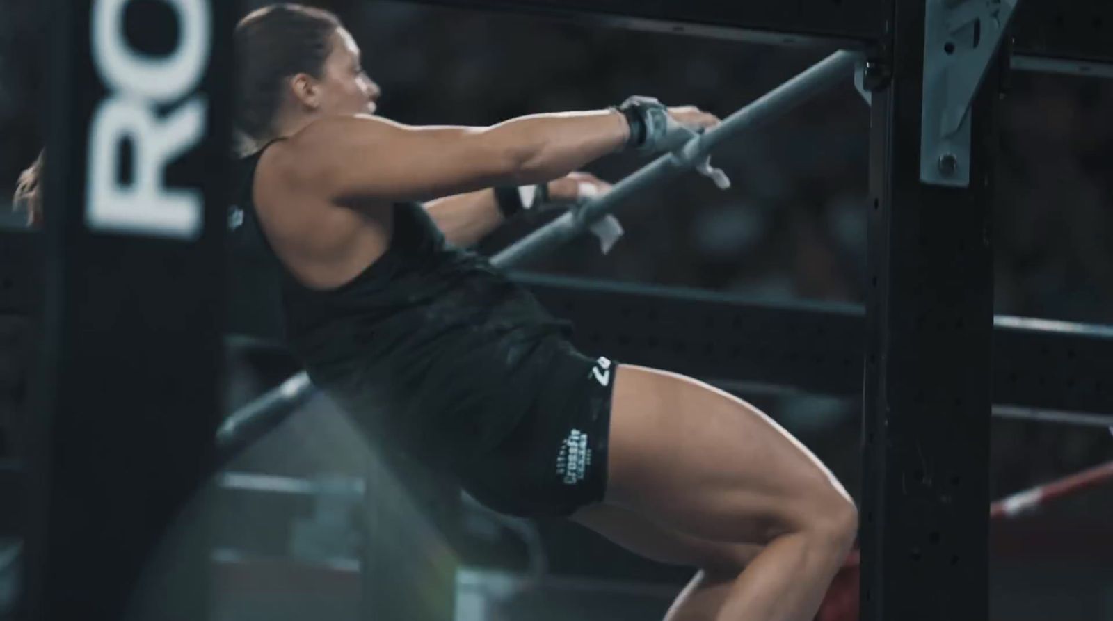 a woman in black shirt and shorts holding a bar