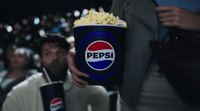 a man holding a can of pepsi in front of a crowd of people