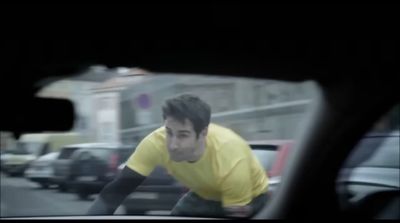 a man in a yellow shirt is riding a bike