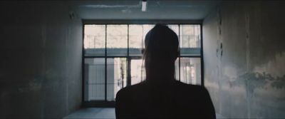 a person standing in a dark room with a window