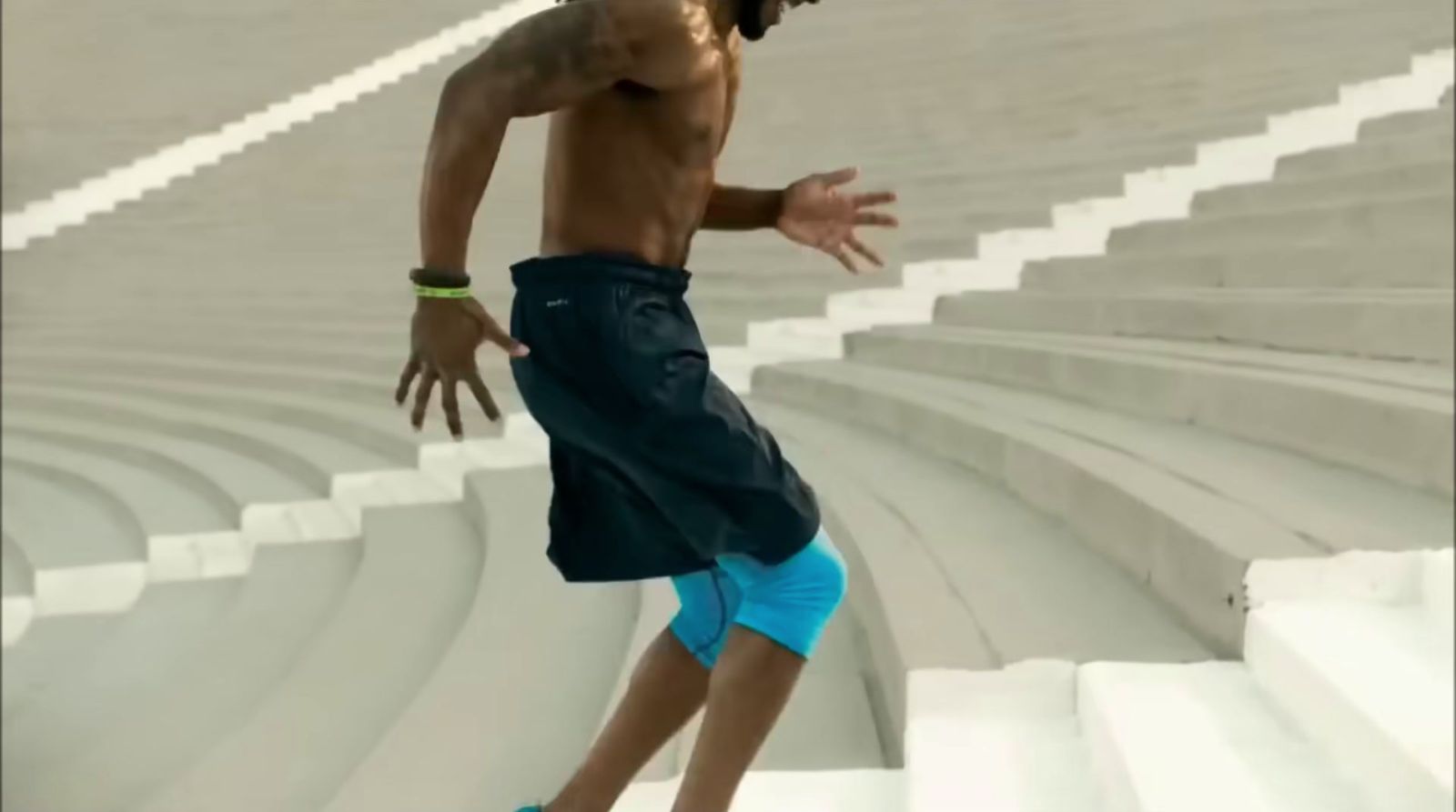 a shirtless man is skateboarding down a set of stairs