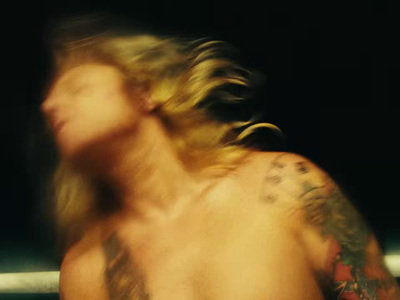 a man with long hair and tattoos on his back