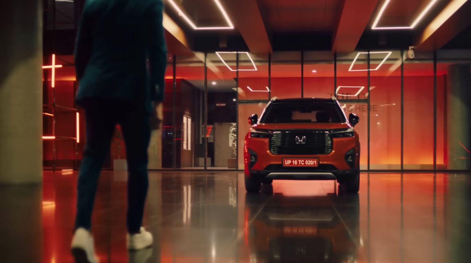 a man standing next to a car in a building