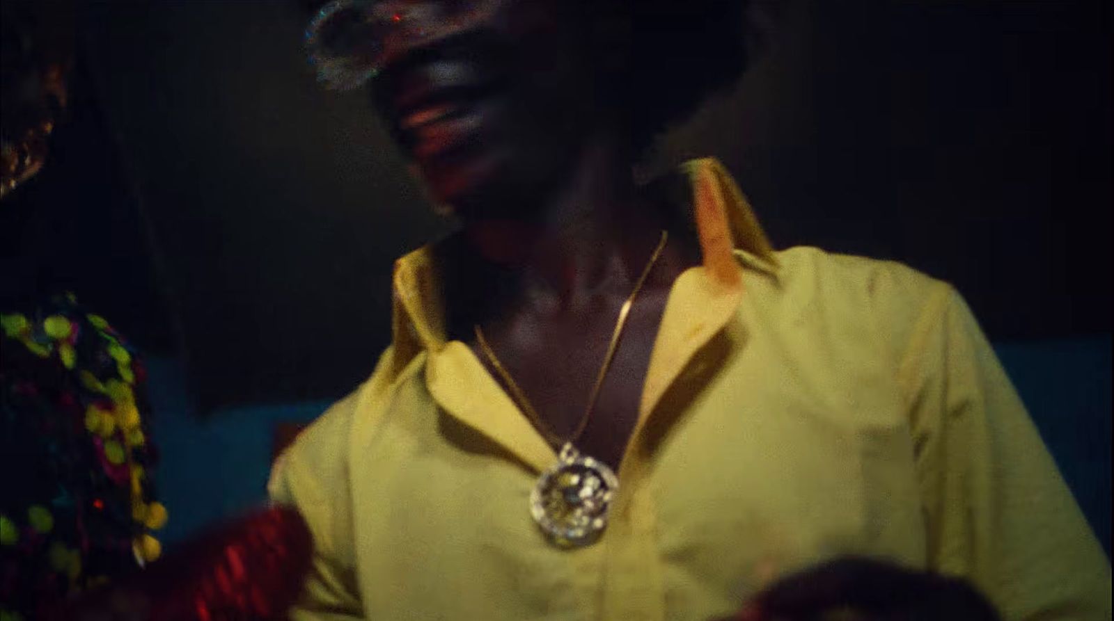 a woman wearing a yellow shirt and a necklace