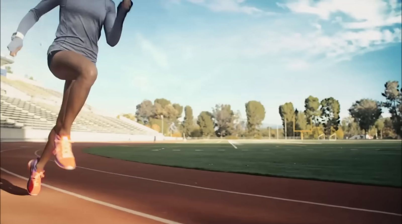 a woman running on a track in a stadium